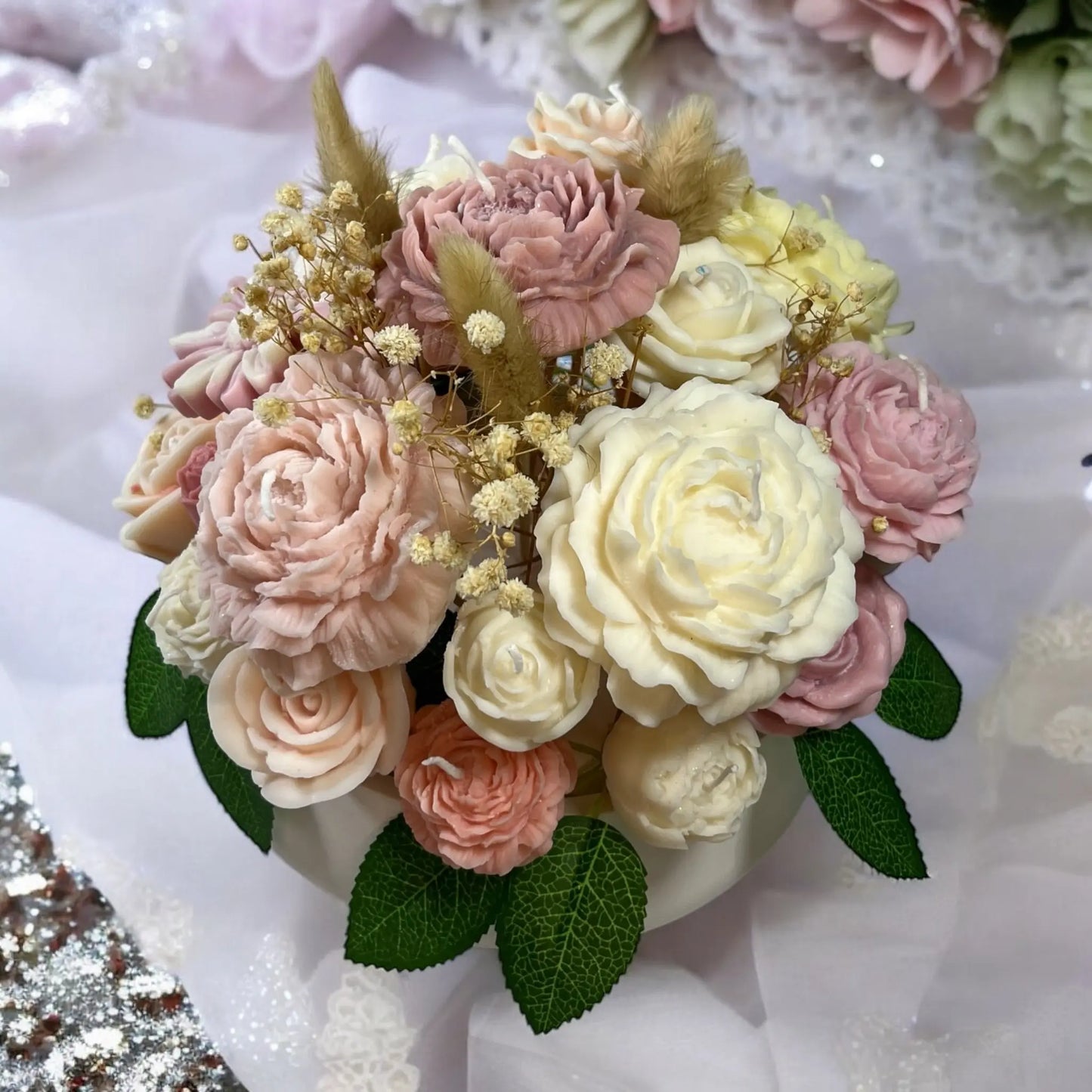 Chic floral candle arrangement in an ornate decorative pot.