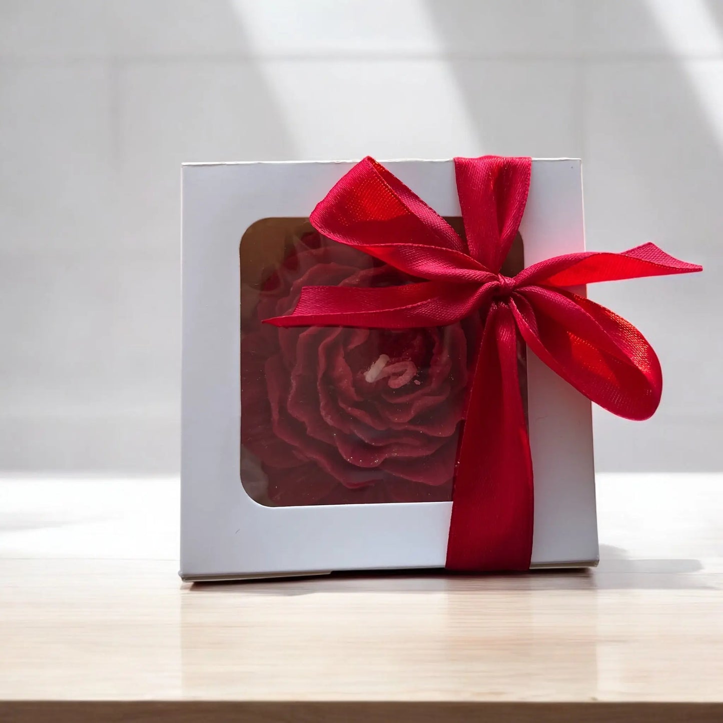 Artistic floral candle with a rich red hue.