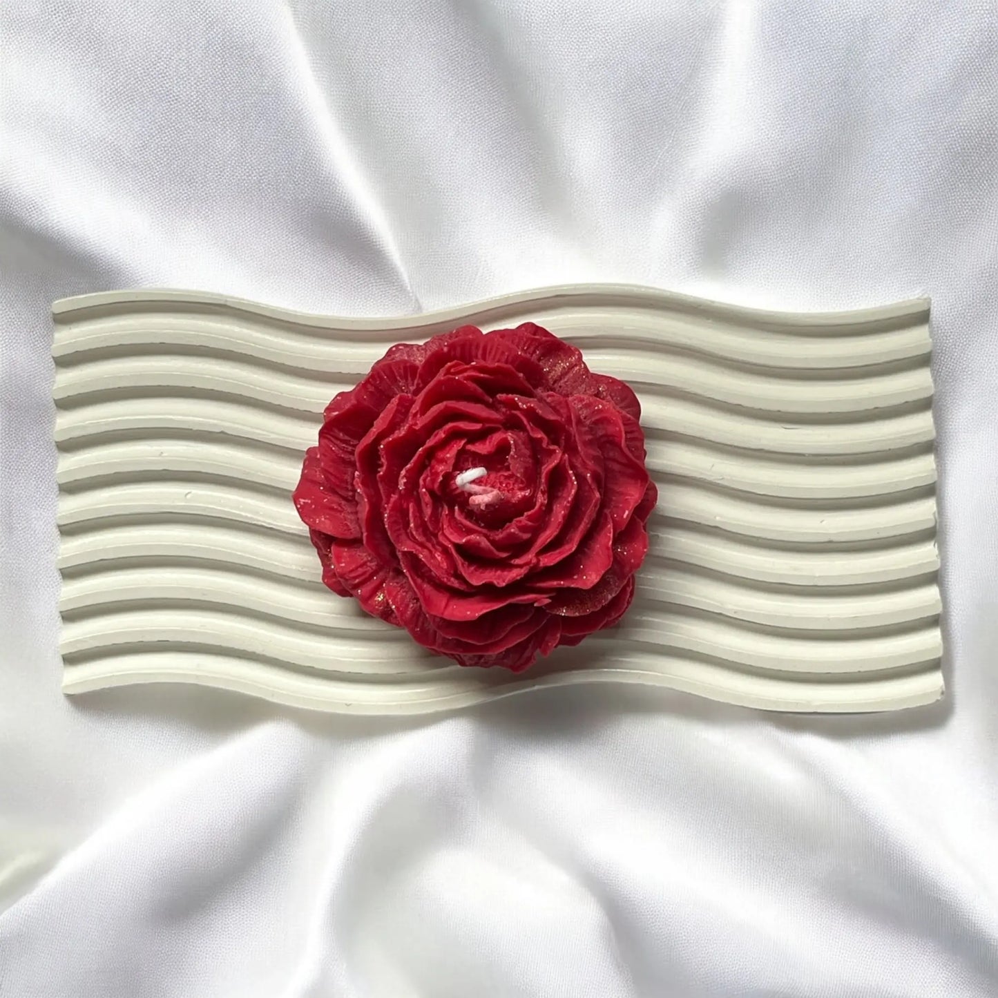 Handmade wax candle shaped like a delicate rose.