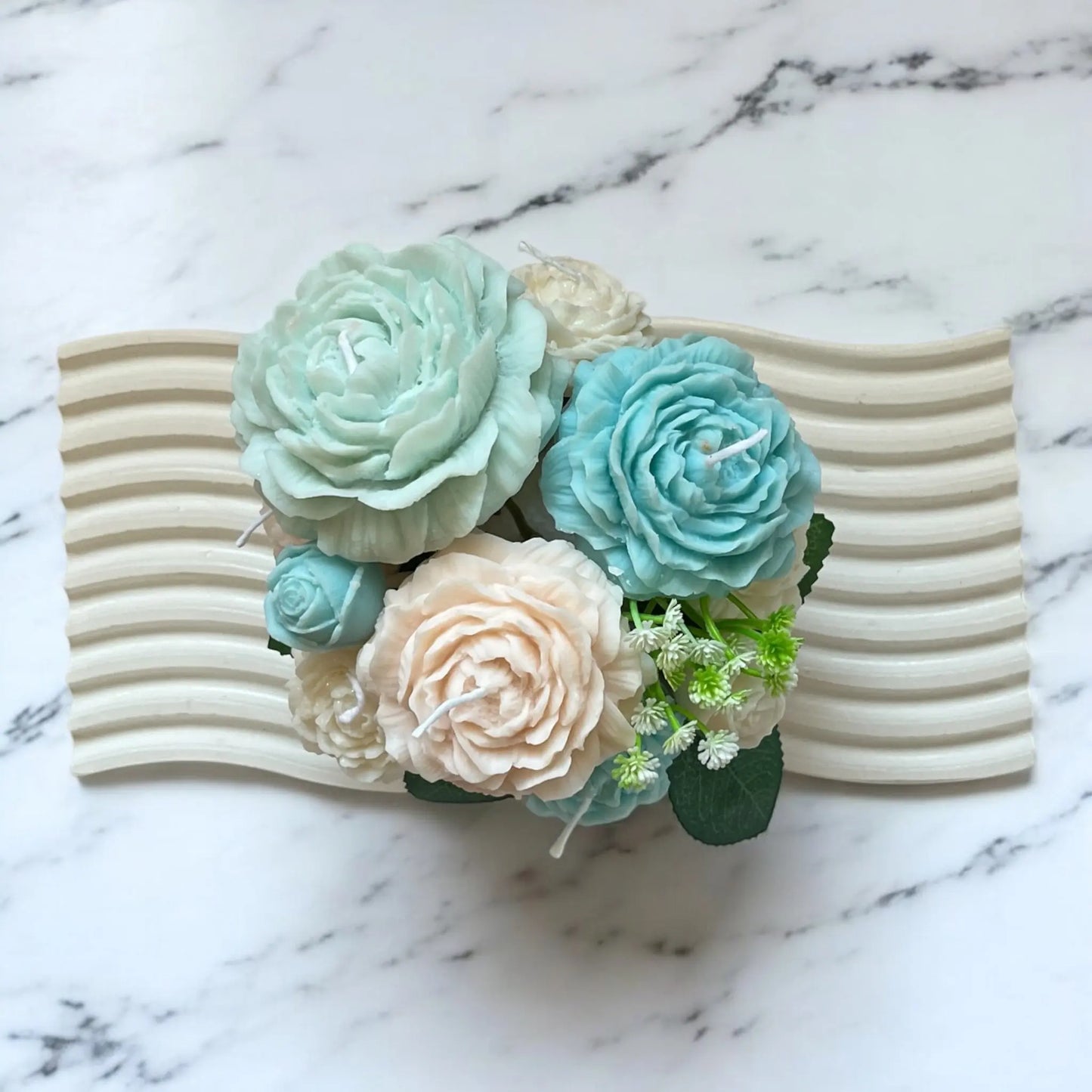 Soft pastel candle bouquet with handcrafted floral details.