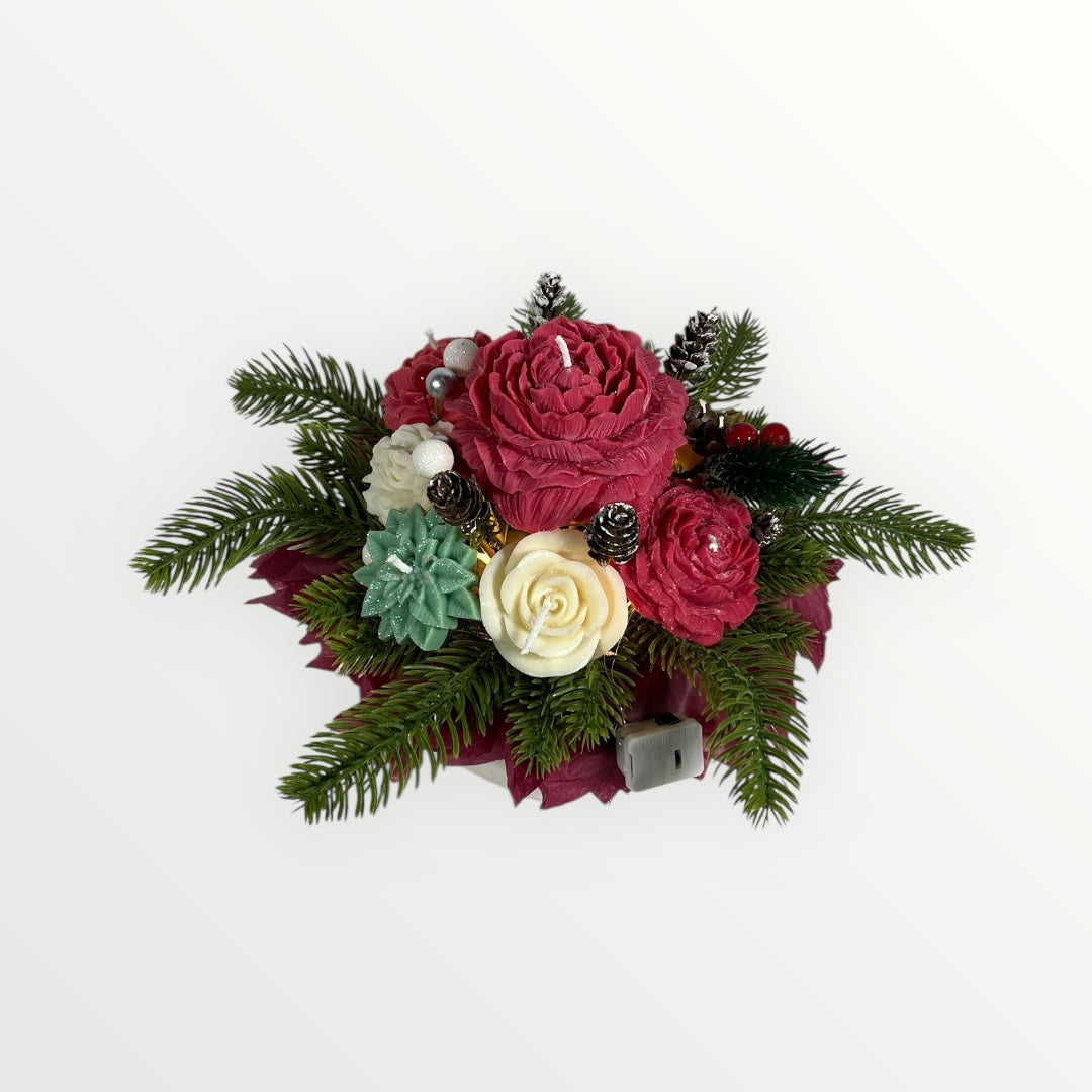 Käsintehty joulukynttiläkimppu, jossa punaisia ja valkoisia kukkakynttilöitä sekä havunoksia.