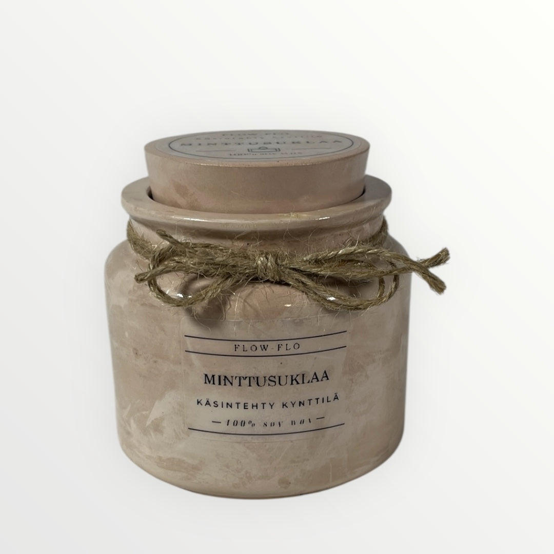 Flow Flo Minttusuklaa -käsintehty tuoksukynttilä vaaleanruskeassa rustiikkisessa purkissa juuttinarukoristeella, mintunlehtiä ja tummaa suklaata ympärillä – raikas ja makea ekologinen soijavaha kynttilä sisustukseen