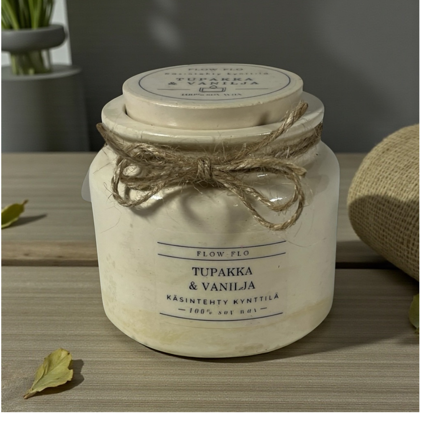 Flow Flo Tabak & Vanilja käsintehty tuoksukynttilä vaaleanbeigessä rustiikkisessa purkissa juuttinarukoristeella puupöydällä – lämmin savuisen tabakin ja makean vaniljan ekologinen soijavaha kynttilä sisustukseen.
