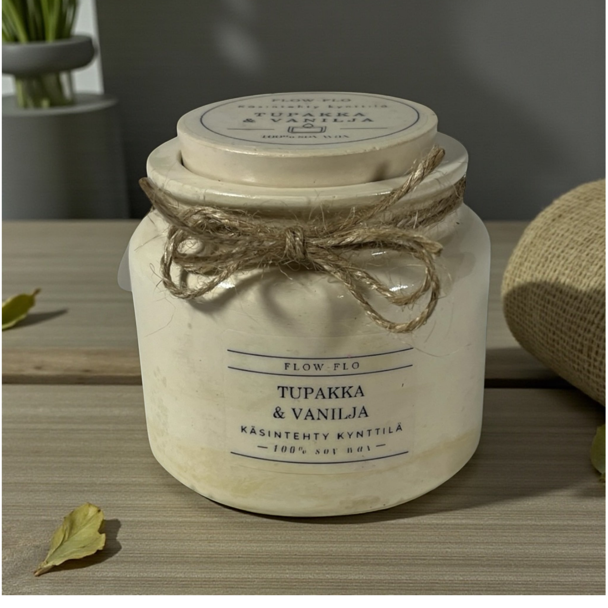 Flow Flo Tabak & Vanilja käsintehty tuoksukynttilä vaaleanbeigessä rustiikkisessa purkissa juuttinarukoristeella puupöydällä – lämmin savuisen tabakin ja makean vaniljan ekologinen soijavaha kynttilä sisustukseen.