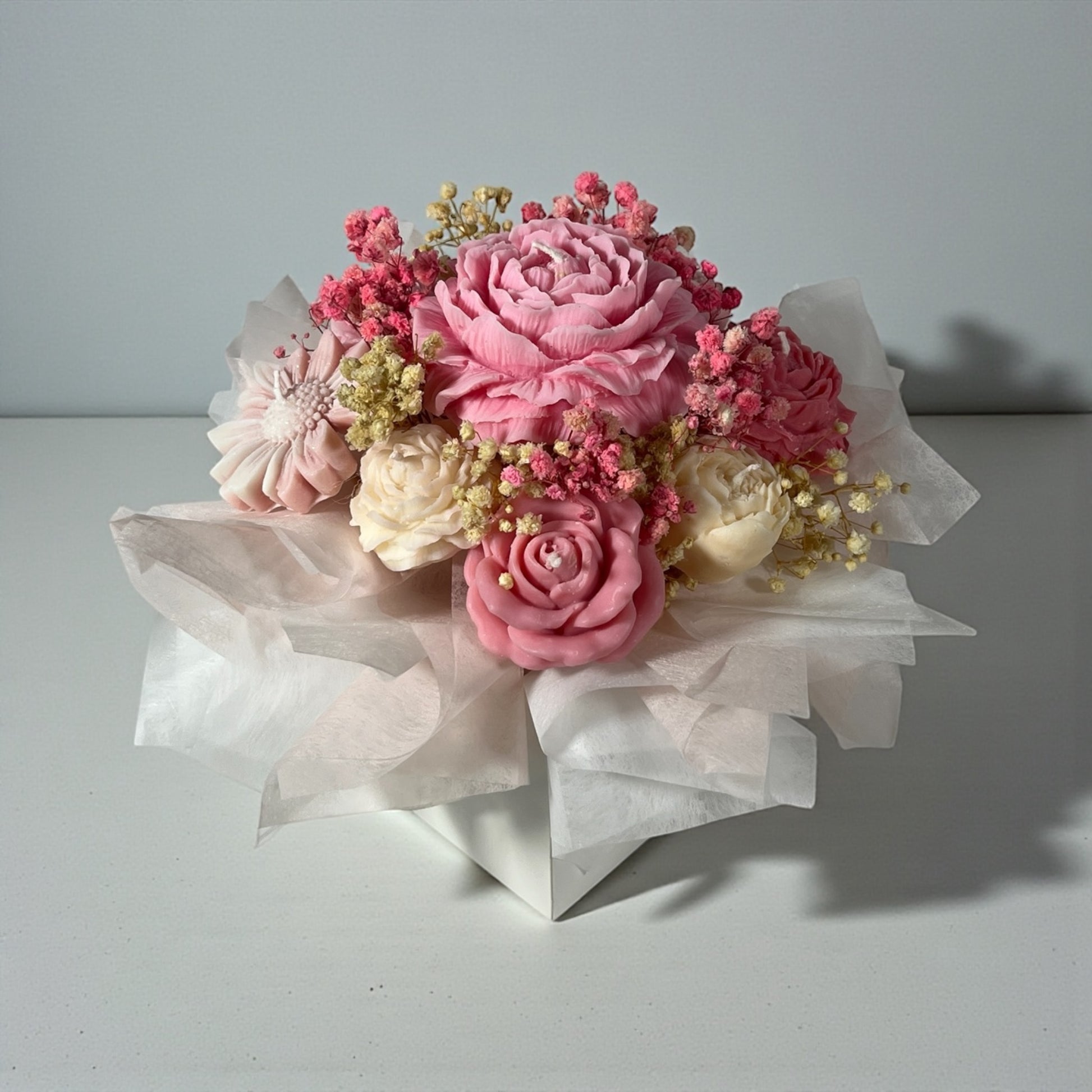 Käsintehty soijavaha kynttiläkimppu romanttisina vaaleanpunaisina ja roosana pionikynttilöinä valkoisessa lahjarasiassa läpinäkyvällä ikkunalla