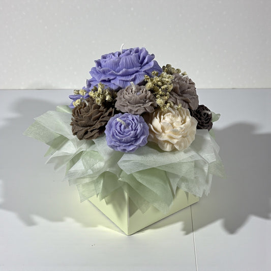 Käsintehty soijavaha kynttiläkimppu pastellililoina ja beigeinä pionikynttilöinä lahjarasiassa läpinäkyvällä ikkunalla