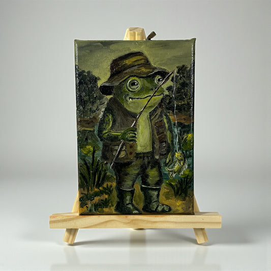 Alkuperäinen öljymaalaus kalastavasta sammakosta Froggies-sarjasta - vihreä sammakko onkivavan kanssa lammen reunalla, käsintehty taideteos