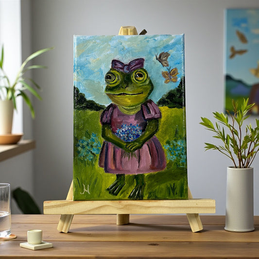 Käsintehty sammakkotaulu kukkien ja perhosten keskellä