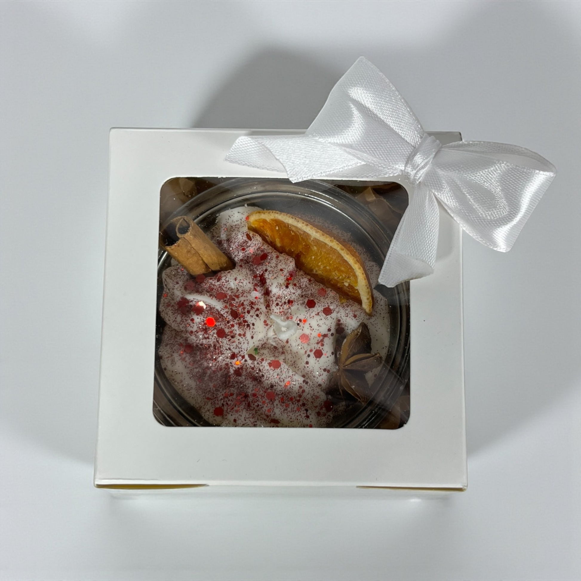 Vininpunainen käsintehty geelikynttilä appelsiinilla ja kanelilla.