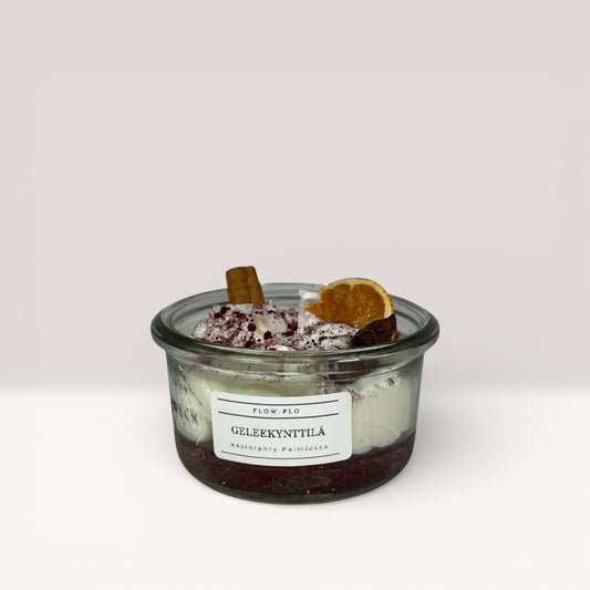 Vininpunainen geelikynttilä appelsiinilla ja kanelilla lasipurkissa