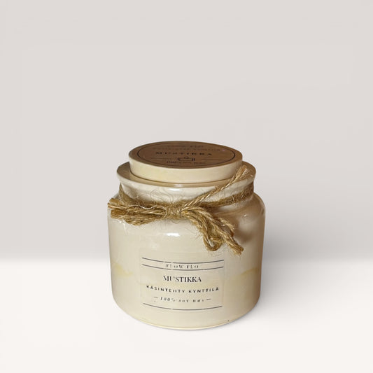 Flow Flo Mustikka -käsintehty tuoksukynttilä valkoisessa rustiikkisessa purkissa juuttinarukoristeella, tuoreita mustikoita ympärillä puupöydällä – raikas ja marjainen ekologinen soijavaha kynttilä sisustukseen