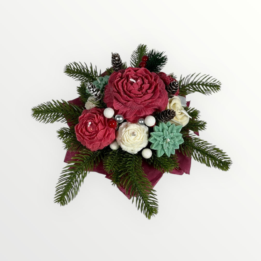 Punainen ja vihreä soijavahasta valmistettu kukkakimppu havuilla ja kävyillä.