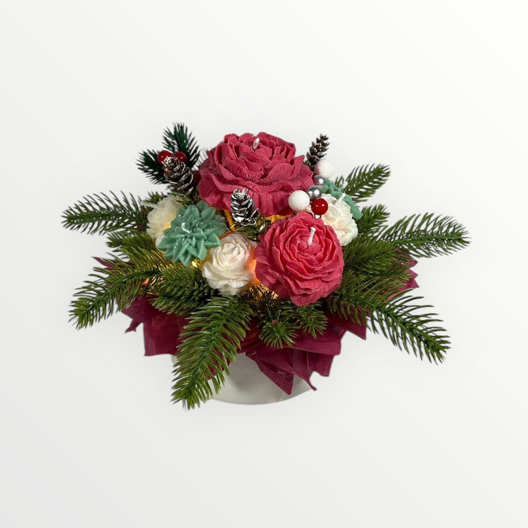 Jouluinen kynttiläkukkakimppu punaisilla ja valkoisilla soijavahakukilla ja havukoristeilla.