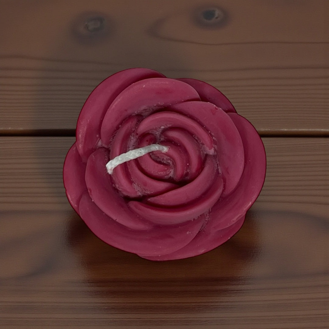 Värillinen vahakynttilä, joka on valettu ruusun muotoon.