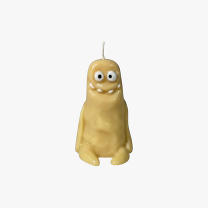 Flow-Flo handmade soy wax candle shaped like a cute yellow monster with big eyes and a wide smile, perfect for quirky decor.