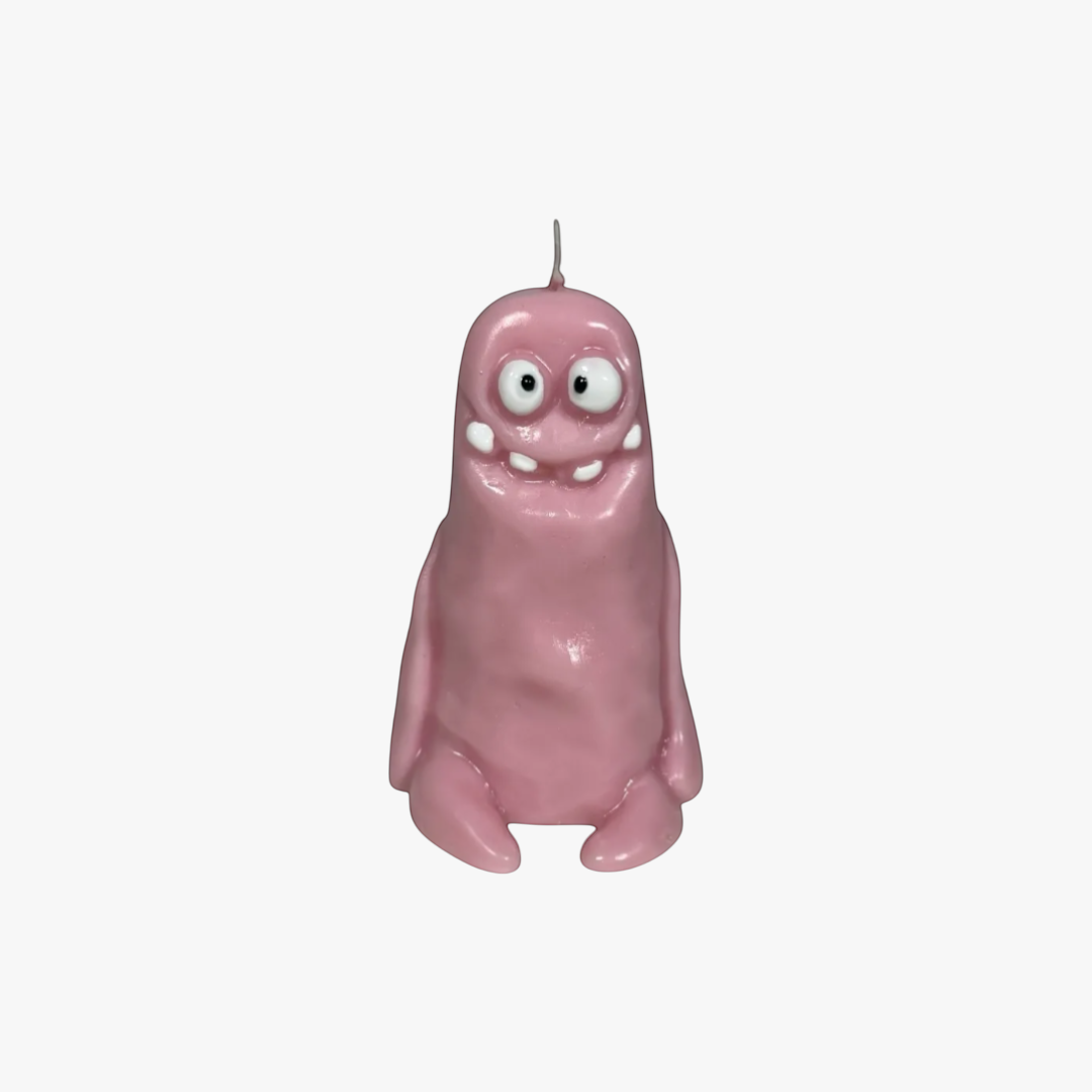 Flow-Flo handmade pink soy wax candle shaped like a cute monster with big eyes and a wide smile.